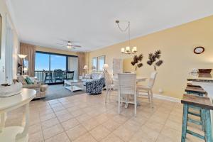 a dining room and living room with a table and chairs at Grand Pointe Unit 303 in Orange Beach