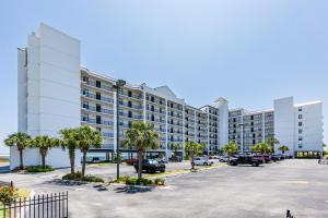 a large apartment building with palm trees in a parking lot at Grand Pointe Unit 303 in Orange Beach
