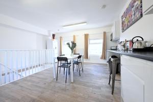 a kitchen and dining room with a table and chairs at Fabulous duplex apartment in Dalston Junction in London