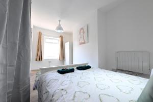 a bedroom with a bed with two pillows on it at Fabulous duplex apartment in Dalston Junction in London