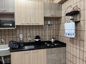 a small kitchen with a sink and a stove at AP Abdon Central Temporada in Joinville