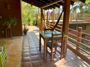 een patio met een tafel en stoelen op een veranda bij Posada Paloma in San Agustinillo
