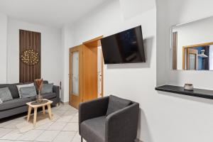 ein Wohnzimmer mit einem Sofa und einem TV an der Wand in der Unterkunft Ferienwohnung am Markt Delitzsch für 6 in Delitzsch
