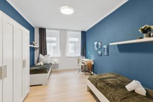 Zimmer mit 2 Betten und blauer Wand in der Unterkunft Ferienwohnung am Markt Delitzsch für 6 in Delitzsch