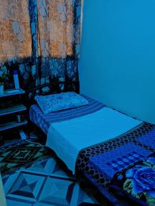 two beds in a room with a blue light at Single Room Near "World Trade Centre&Beach" Abudhabi in Abu Dhabi