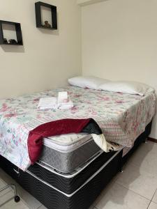 a bedroom with a bed with a blanket on it at AP Abdon Central Temporada in Joinville