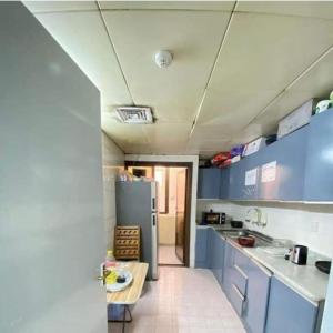 a kitchen with blue cabinets and a refrigerator at Single Room Near "World Trade Centre&Beach" Abudhabi in Abu Dhabi