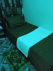 a bedroom with two beds with a blue light at Single Room Near "World Trade Centre&Beach" Abudhabi in Abu Dhabi
