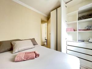 a bedroom with a bed with a pink towel on it at Prédio no coração de Curitiba - Ed. Charlie Chaplin in Curitiba