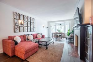 Beautiful and Spacious Luxury Home في تورونتو: غرفة معيشة مع أريكة حمراء وطاولة