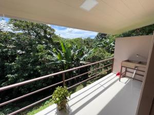 Elle comprend un balcon offrant une vue sur les arbres. dans l'établissement Apartamentos en sarchi, à Sarchí