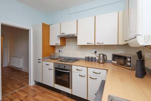 a kitchen with white cabinets and a stove top oven at Derby central 4 bed house - Free parking in Derby