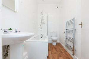 Derby central 4 bed house - Free parking في ديربي: حمام أبيض مع حوض ومرحاض