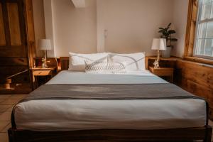 a bedroom with a large white bed with two lamps at The Village Inn in East Burke