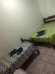 カラグアタトゥーバにあるCasa próximo a praia com churrasqueira e ar condicionado!のベッド2台が隣同士に設置された部屋です。