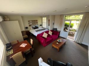 a living room with a bed and a red couch at Pinot Villas in Martinborough 