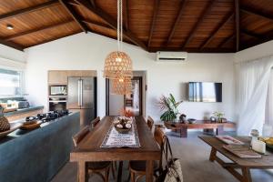 una cucina e una sala da pranzo con tavolo in legno di Orixás Residence a Morro de São Paulo