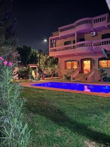 a large house with a swimming pool at night at Paradise house in Marrakesh