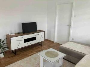 ein Wohnzimmer mit einem TV und einem Sofa in der Unterkunft Apartman Vrbas 1 + Podzemna garaza in Banja Luka
