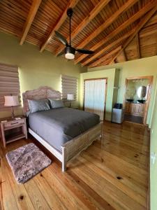 Schlafzimmer mit einem Bett und einem Deckenventilator in der Unterkunft Casa Corazon Striking Beach Home in Utila