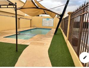 una piscina con una sombrilla encima en Casa con alberca compartida Netflix Disney + Amazon TV, en Hermosillo