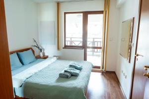 ein Schlafzimmer mit einem Bett mit Handtüchern darauf in der Unterkunft 2-bedroom apt, 2min walk to ski path, 7-8 min walk to gondola in Bansko