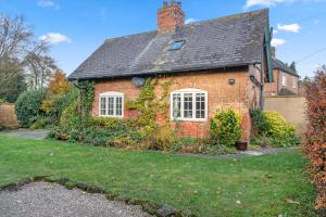uma velha casa de tijolos com hera a crescer nela em Beautiful 2 Bedroom Cottage in Oxton em Oxton