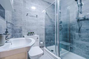 a bathroom with a shower and a toilet and a sink at LFC Football Apartment Anfield in Liverpool