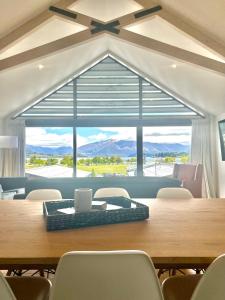 a dining room with a table and a large window at Aspiring View Apartments in Wanaka