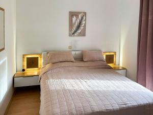 a bedroom with a large bed with two windows at Apartments Helena in Lopar