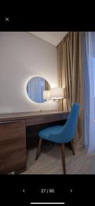 a desk with a blue chair and a mirror at Hotel Rile Men Blue in Niš