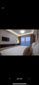 a bedroom with a white bed and a window at Hotel Rile Men Blue in Niš
