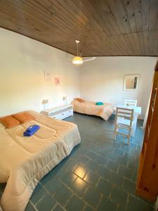a bedroom with two beds and a table and a chair at Monoambiente Noah in Ezeiza
