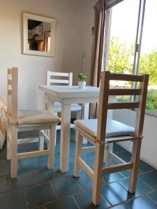 a white table and chairs with a table and a window at Monoambiente Noah in Ezeiza