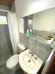 a bathroom with a white toilet and a sink at Monoambiente Noah in Ezeiza +13 photos