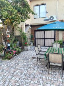a patio with a table and chairs and an umbrella at Monoambiente Noah in Ezeiza