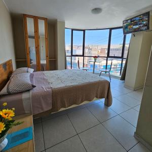 a bedroom with a bed and a balcony with a view at Hostal Santa Barbara in Ilo