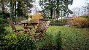 three chairs sitting around a table in a yard at La gazza ladra in Namur