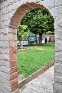 un arco en una pared de piedra con un campo de hierba en Lago Manantial, en Independencia
