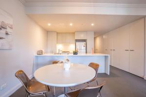 eine Küche und ein Esszimmer mit einem weißen Tisch und Stühlen in der Unterkunft Olympic Park 2 Bedrooms Charm Family Friend Free Parking in Sydney