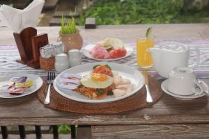 una mesa con un plato de comida para el desayuno. en tiny's house en Ubud
