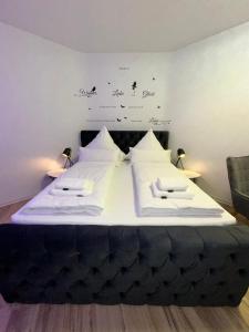 a large bed with white sheets and pillows on it at Modern Apartments Neuburg 5 - TOP NEU - 3 Zimmer, Komfort, Zentrum, Wi-Fi, Smart TV, Garage, Küche in Neuburg an der Donau