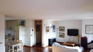een woonkamer met een bank en een tafel en een keuken bij Court of Artist Friuli in Sedegliano