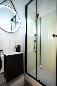 y baño con ducha, lavabo y espejo. en Design Loft - 200qm2 - Heimkino - Bestlage - Parkplatz, en Wiesbaden