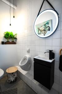 baño con urinario, lavabo y espejo en Design Loft - 200qm2 - Heimkino - Bestlage - Parkplatz, en Wiesbaden