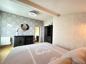 エペルネーにあるLe Domaineの大きなベッドと鏡のある寝室