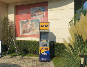 an atm machine sitting in front of a building at Beach View Apartment in Shkorpilovtsi