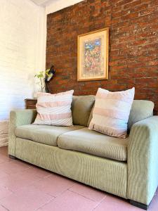 a couch sitting in front of a brick wall at Hospedaje Noah in Ezeiza