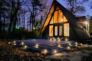 a house with a patio with lights in front of it at NJ Lakefront A-Frame, Millville, NJ - 2 bedroom Cabin Home in Millville