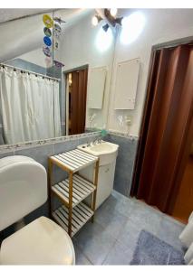 a bathroom with a sink and a toilet and a mirror at Hospedaje Noah in Ezeiza